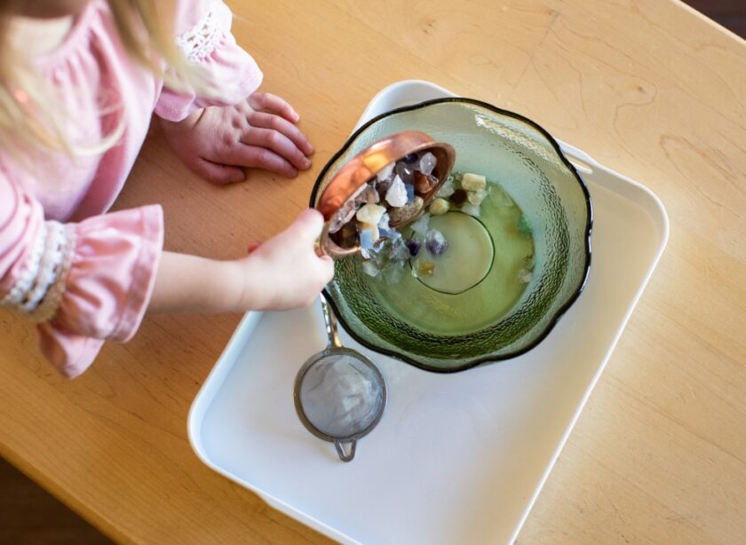 Montessori objects being poured into a bowl.