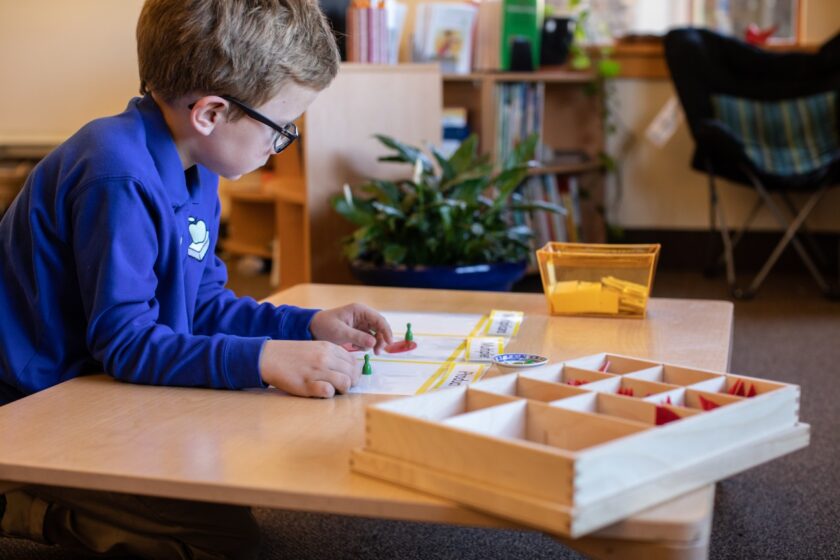 Boy playing with math learning materials.