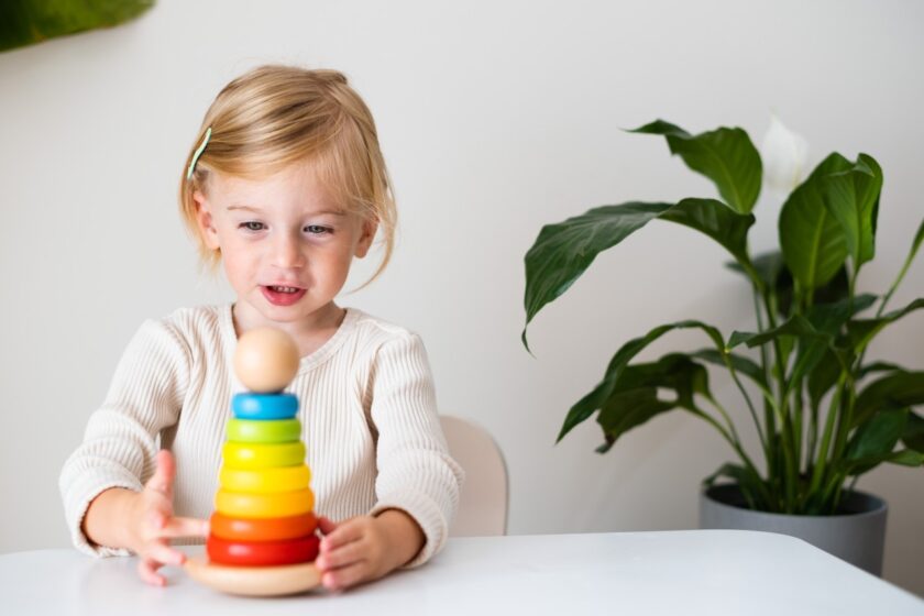 Blonde girl using developmental toy.