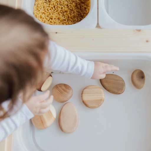 Child learning with wood items.